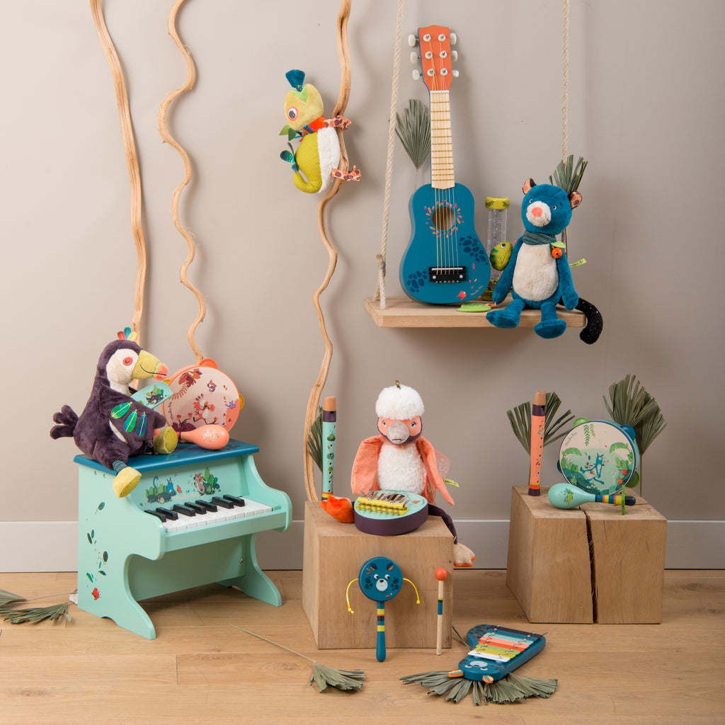 Colourful children's musical toys including a piano, guitar, and various instruments on a wooden floor.