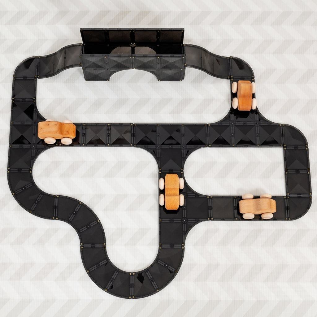 Top-down view of a winding CONNETIX magnetic tile road with wooden toy cars and a bridge