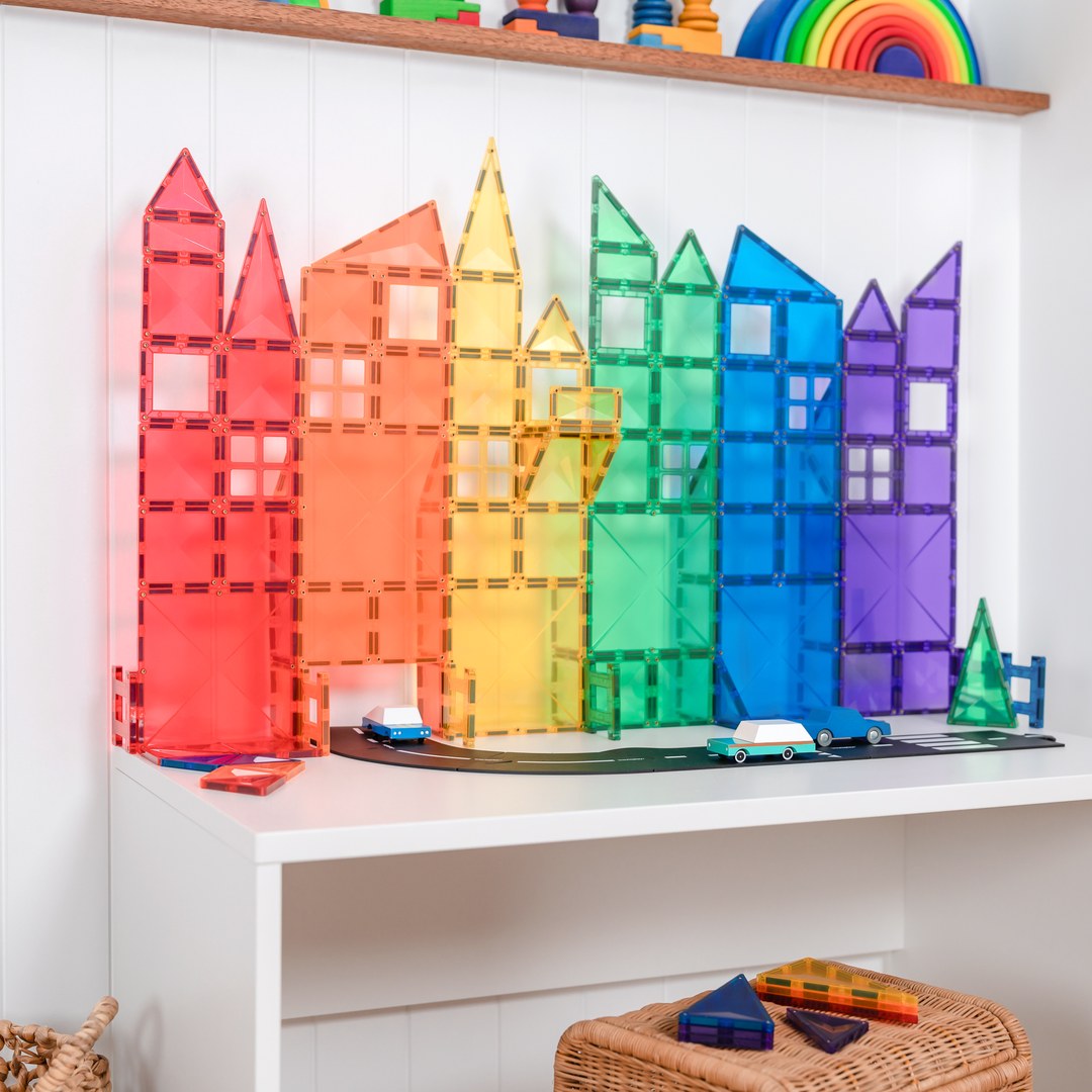 Rainbow city skyline of CONNETIX magnetic tile towers with wooden toy cars on a road