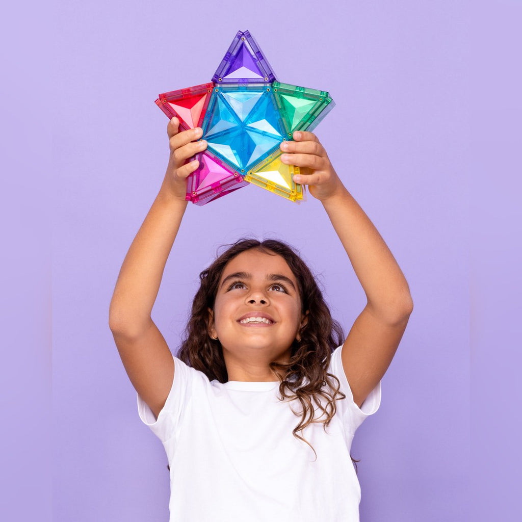 Girl holding a CONNETIX magnetic tile star up above her head
