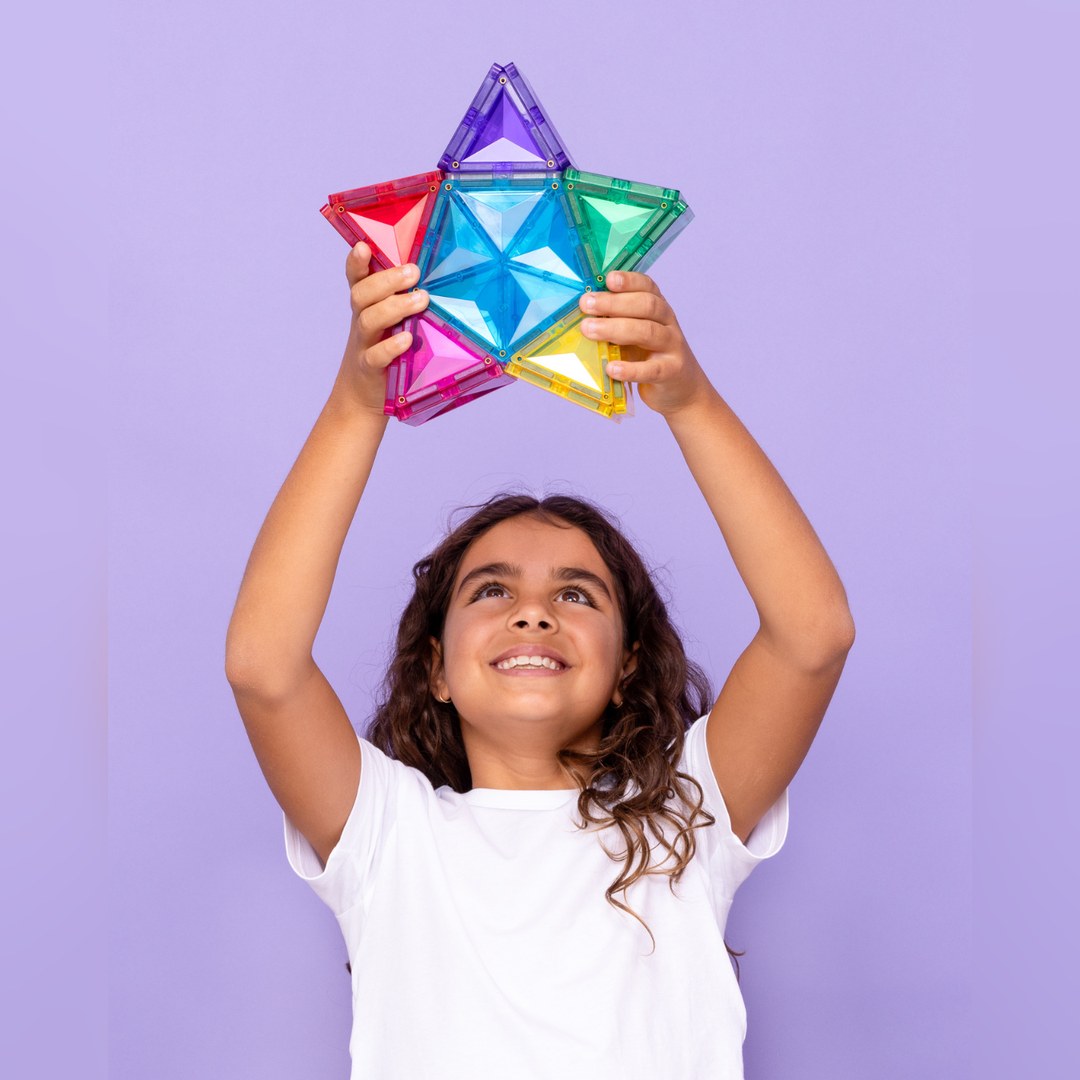 Girl holding a CONNETIX magnetic tile star up above her head