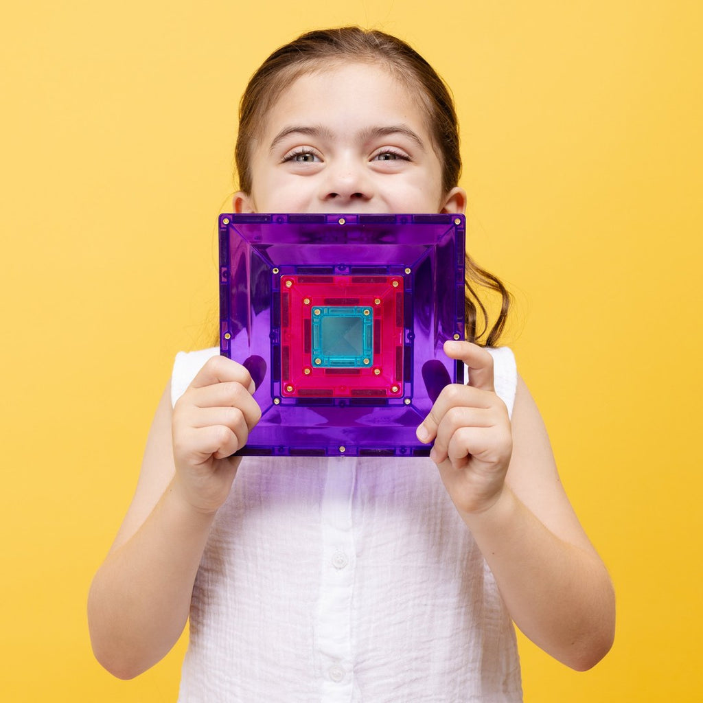 Smiling girl holding a purple CONNETIX portal tile with smaller tiles nested inside