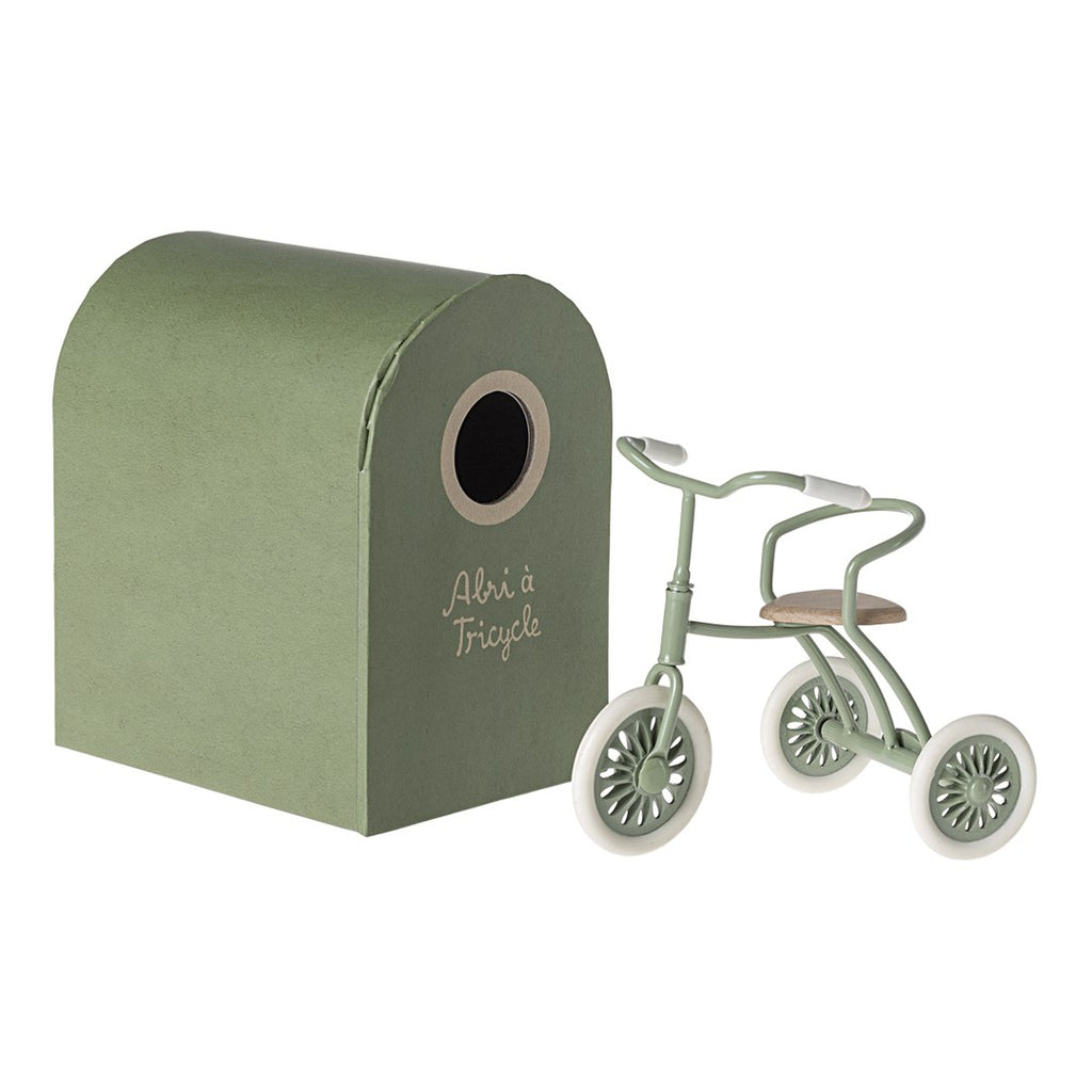 Maileg green tricycle beside its Abri à Tricycle green cardboard garage box