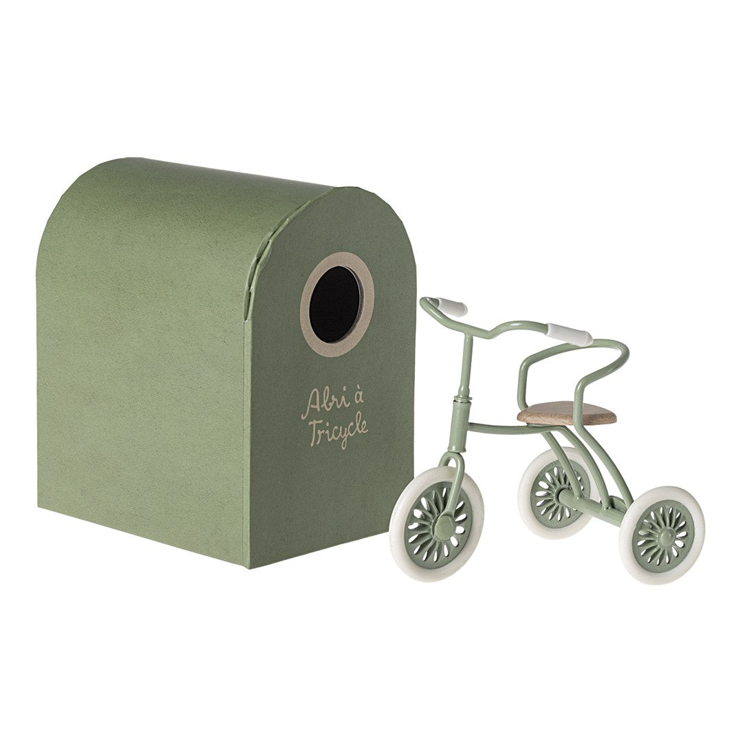 Maileg green tricycle beside its Abri à Tricycle green cardboard garage box