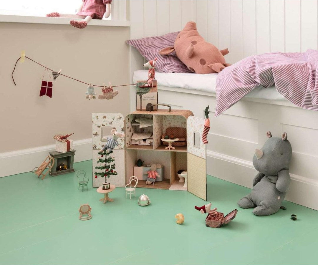 Maileg SuitCasa open on a green floor in a child's bedroom with mice, a Christmas tree and a plush rhino
