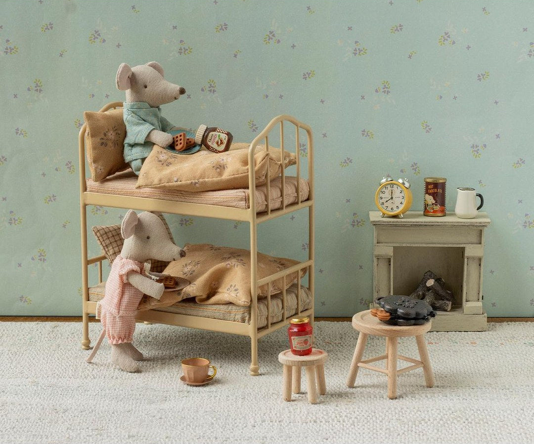 Maileg mice in pyjamas having breakfast on the wheat bunk bed with a fireplace and stools