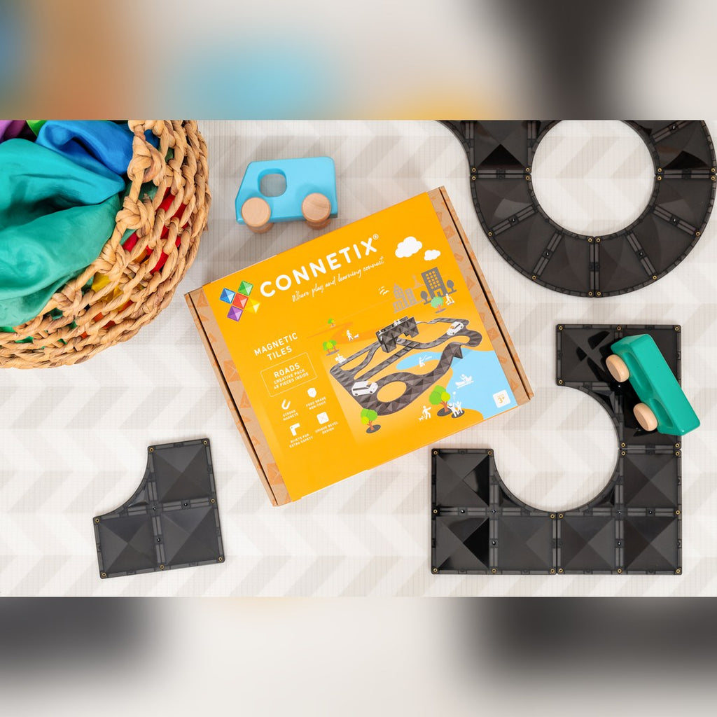 CONNETIX Creative Roads Pack box beside road tiles and wooden toy cars