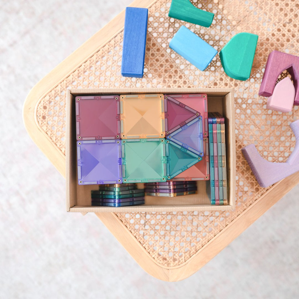 CONNETIX Pastel Starter Pack tiles stored in their box on a rattan table with wooden blocks