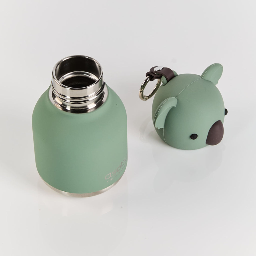 Green water bottle with a small green animal-shaped keychain on a white background