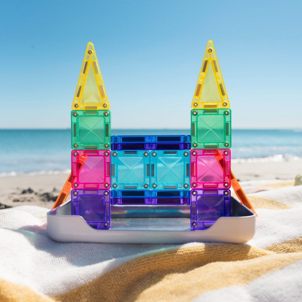 Mini magnetic tile castle built in the CONNETIX travel tin on a beach towel by the sea
