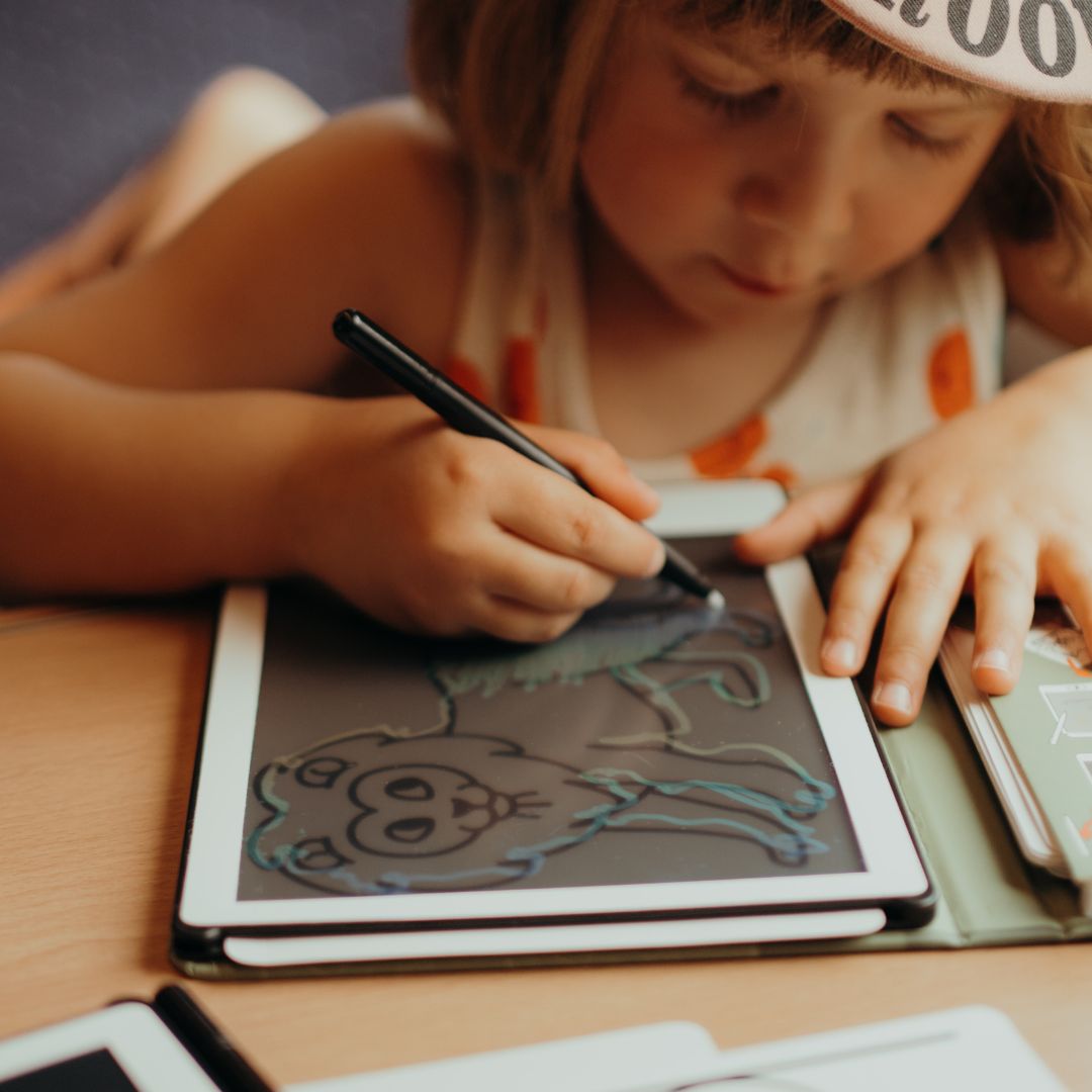 Child tracing a refill card on the Kidywolf KIDYDRAW MINI drawing tablet
