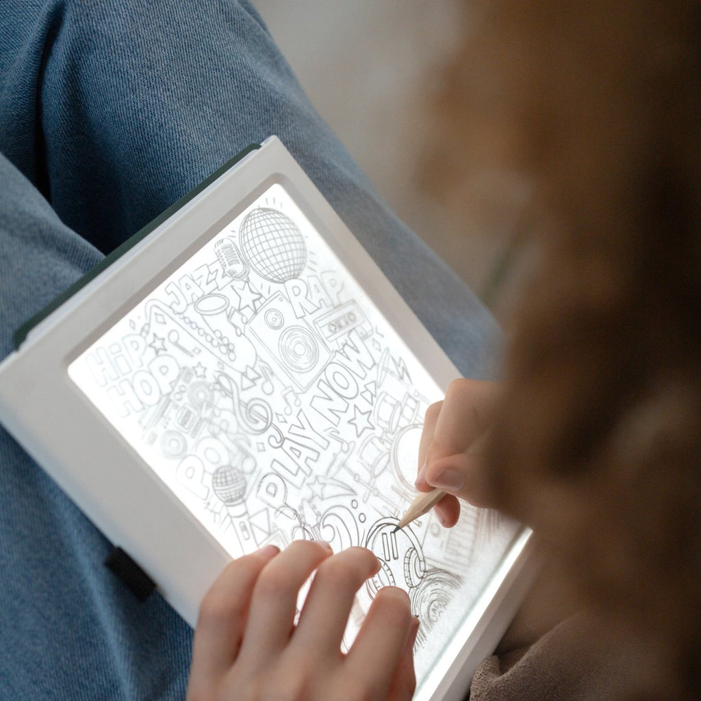 Child tracing a detailed Meli Melo picture on the illuminated KIDYDRAW Pad