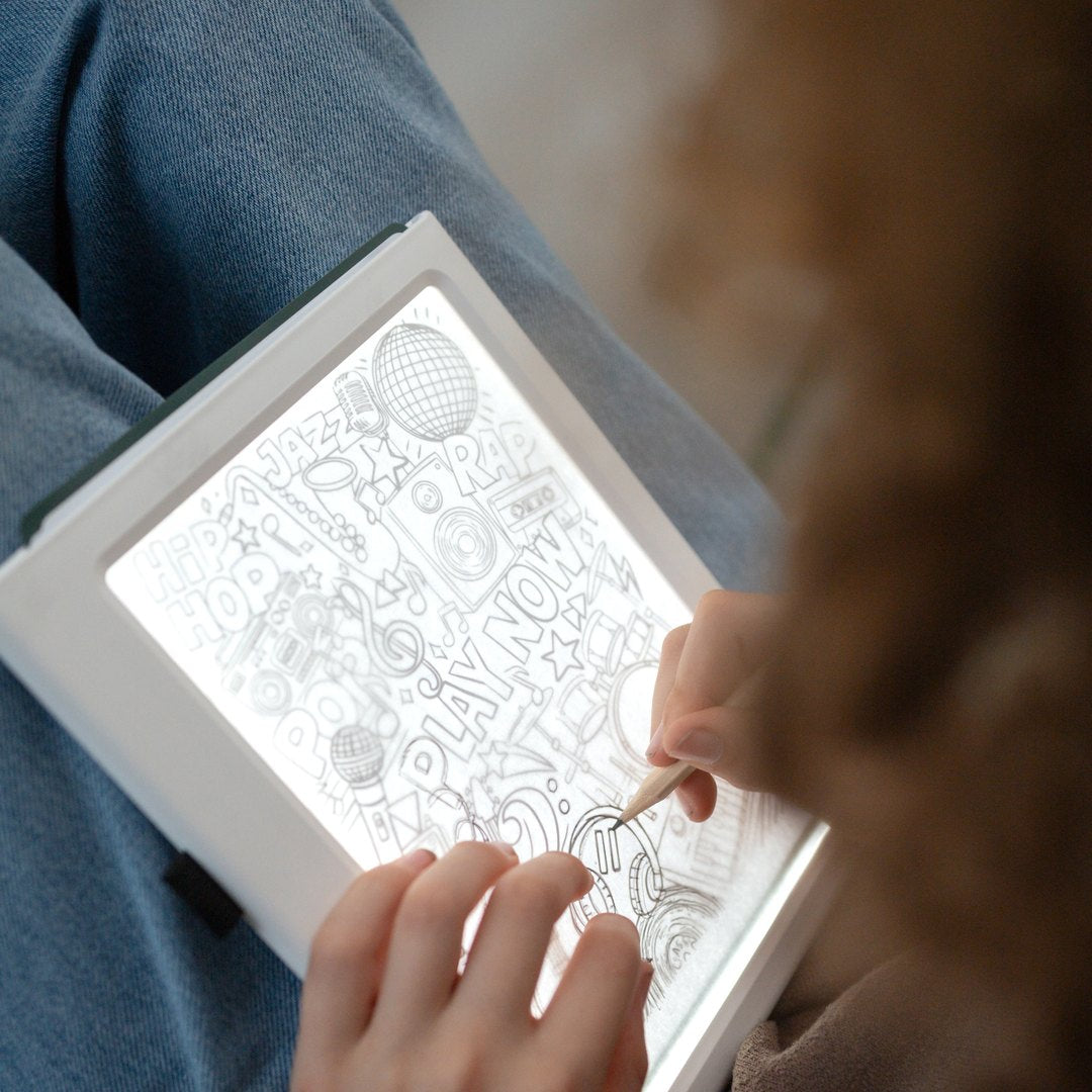 Child tracing a detailed Meli Melo picture on the illuminated KIDYDRAW Pad