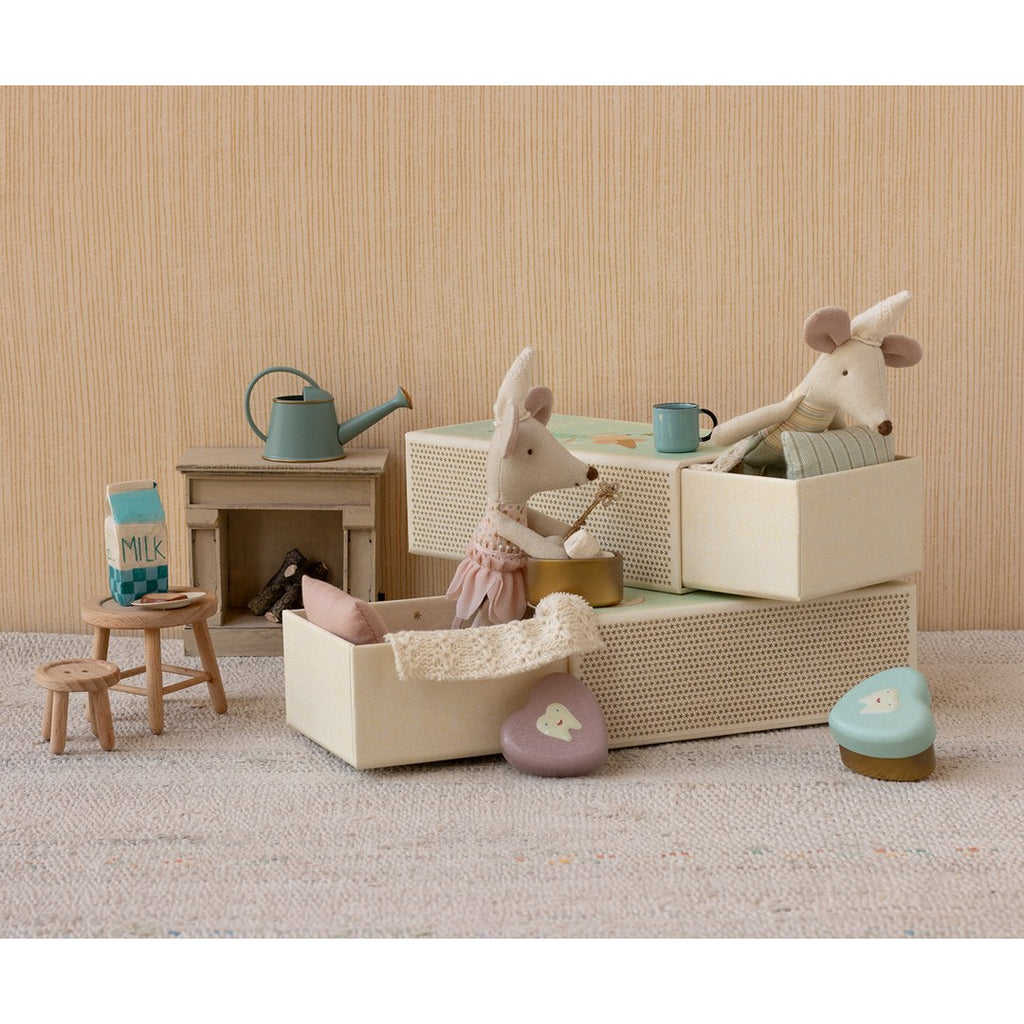 Maileg Tooth Fairy mice playing among stacked matchbox beds with a tooth fairy heart tin, tiny stools and a milk carton