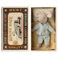 Maileg little brother mouse in mint polka dot pyjamas lying in his matchbox bed, Mouse Race matchbox lid beside it