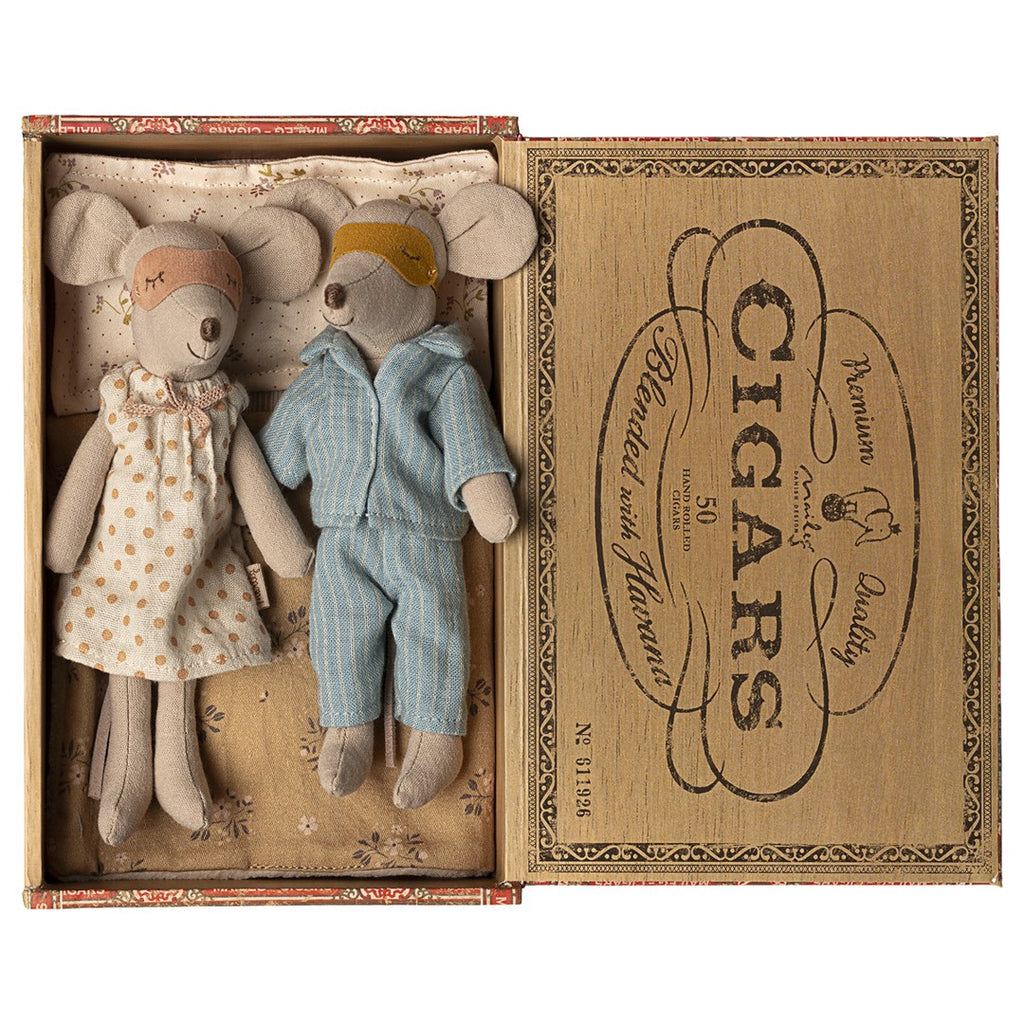 Maileg Mum and Dad mice wearing sleep masks, in a floral nightdress and blue striped pyjamas, lying in a Havana cigar box bed