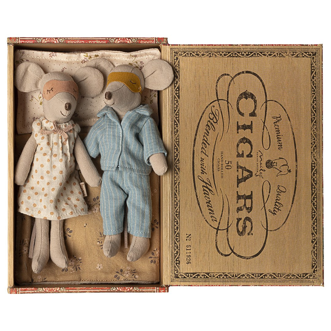 Maileg Mum and Dad mice wearing sleep masks, in a floral nightdress and blue striped pyjamas, lying in a Havana cigar box bed