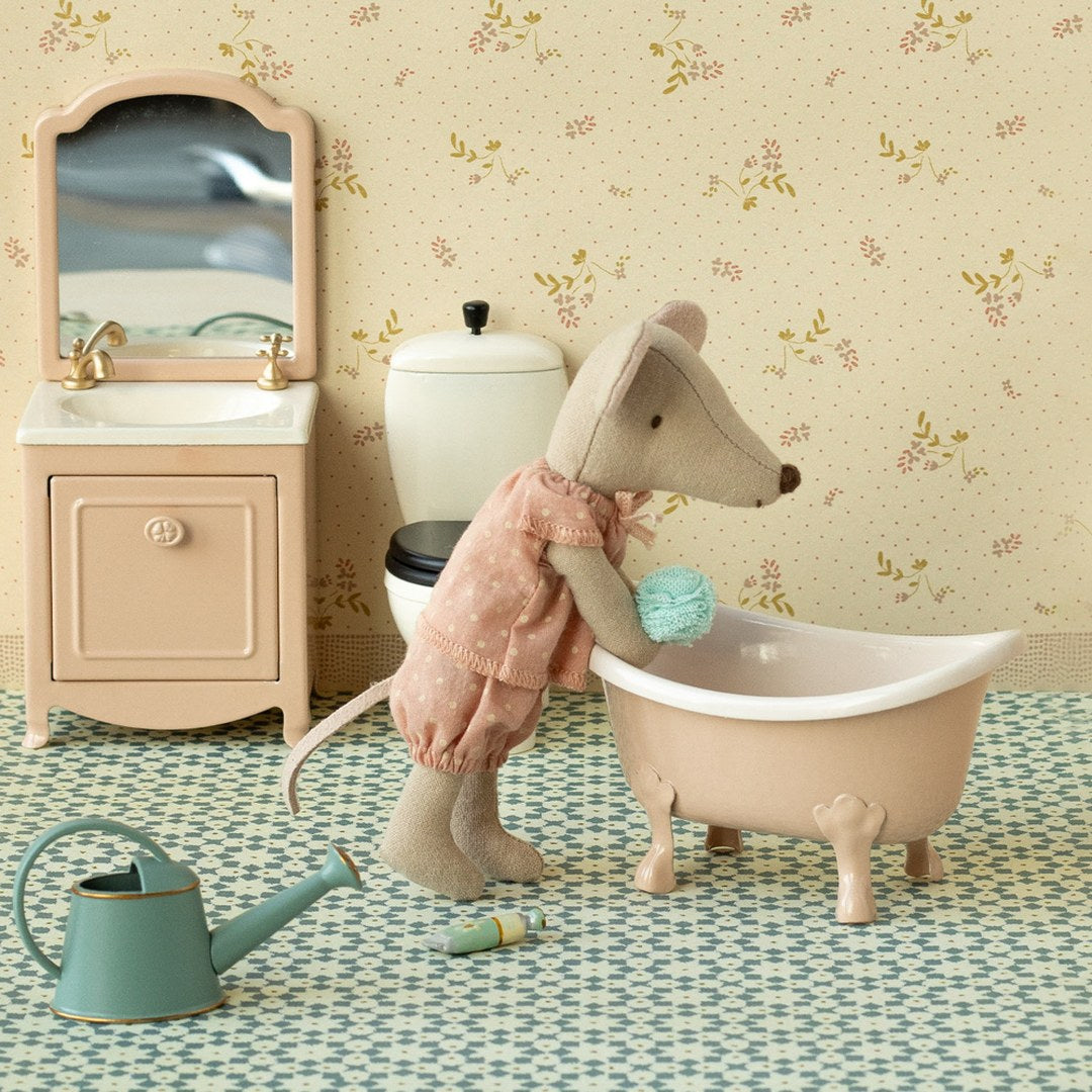 Maileg big sister mouse in a pink polka dot dress washing in a pink clawfoot bath, with a vanity mirror and watering can