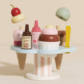 Toy ice cream set with various toppings and a stand on a beige background