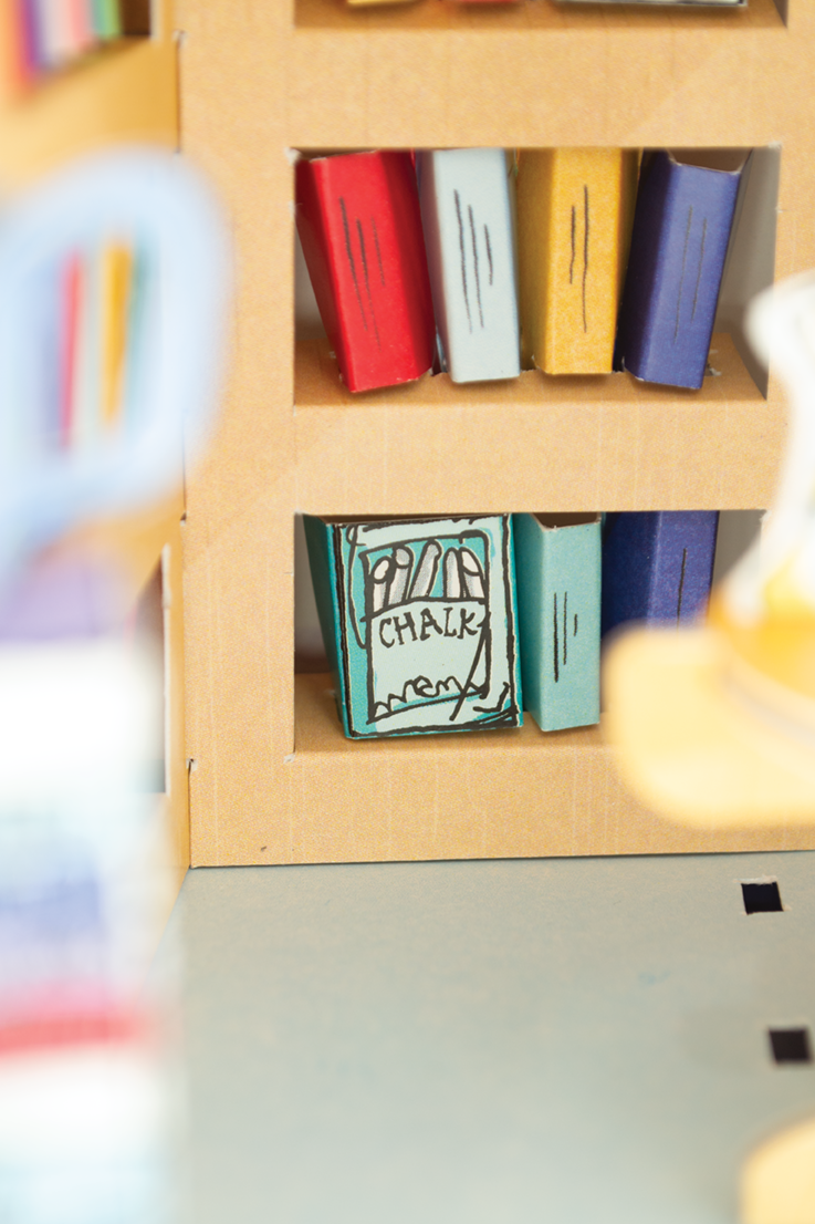 Colorful books on a wooden shelf with a small box labeled 'Chalk' in front.
