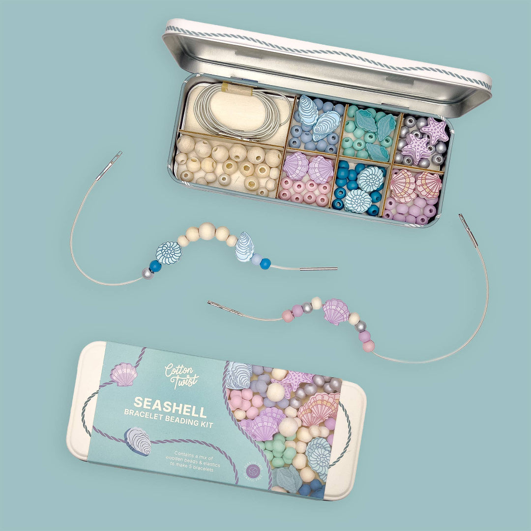 Seashell bracelet beading kit with beads and tools on a blue background