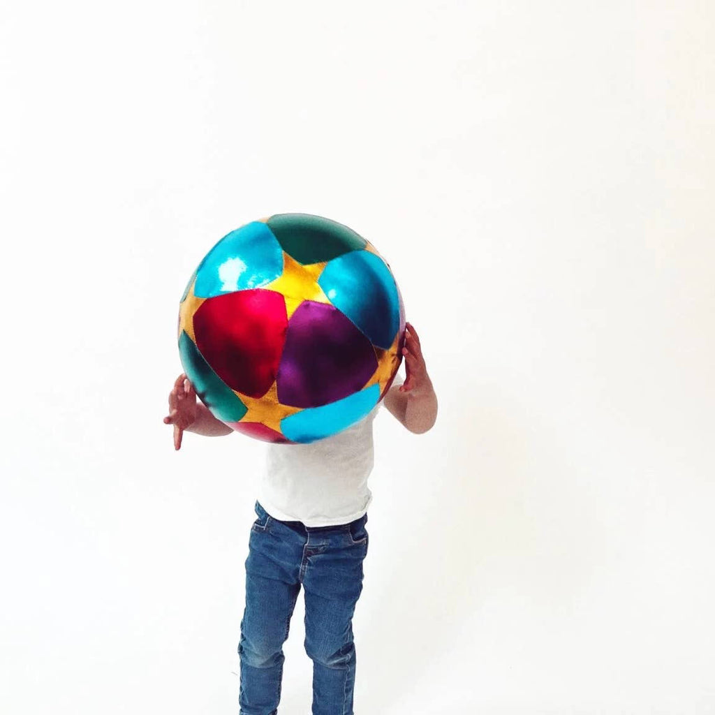 Person holding a colorful beach ball against a white background