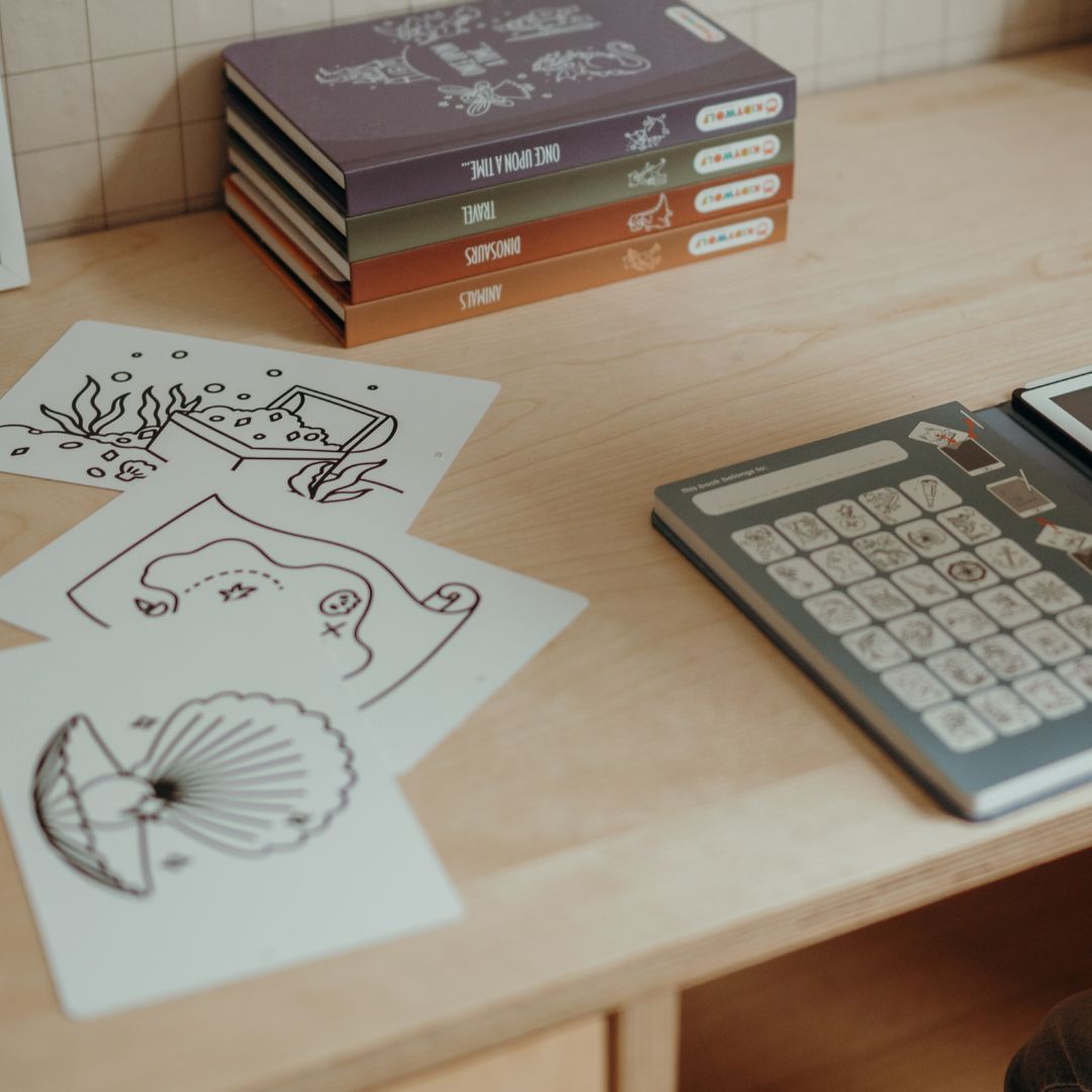 Pirate refill cards with a treasure chest, treasure map and seashell laid on a wooden desk beside a Kidywolf drawing book