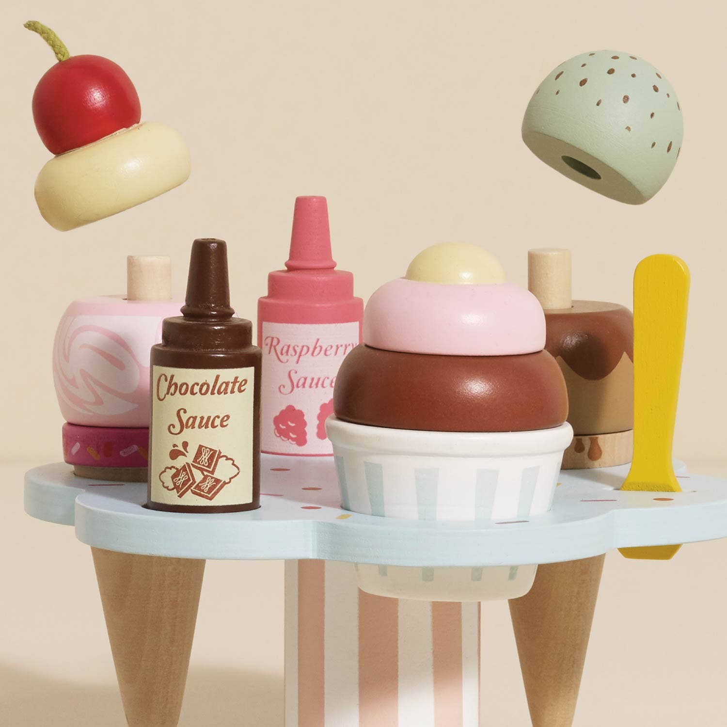 Toy ice cream set with toppings and sauces on a beige background
