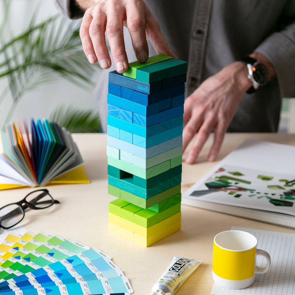 Block Design Warm Gradient Tower, a wooden tumbling tower game with painted blocks in a pink, coral and red gradient