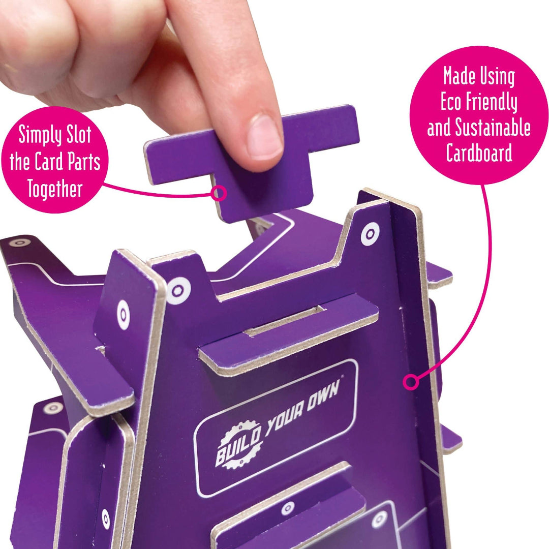 Purple cardboard craft kit with 'Build Your Own' text, hand assembling parts, and eco-friendly label.