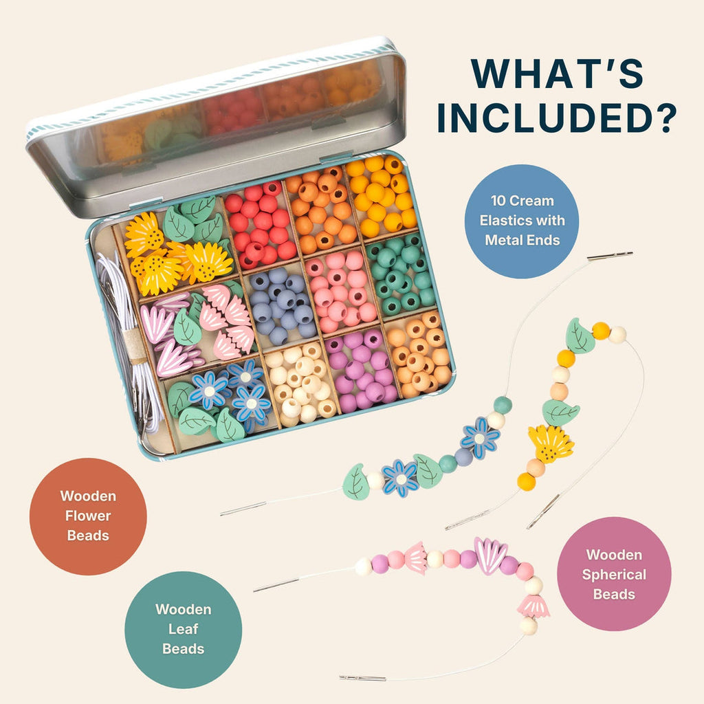 Open tin of wooden flower, leaf and round beads with two bracelets, with labels for what's included: 10 cream elastics with metal ends, wooden flower beads, wooden leaf beads and wooden spherical beads