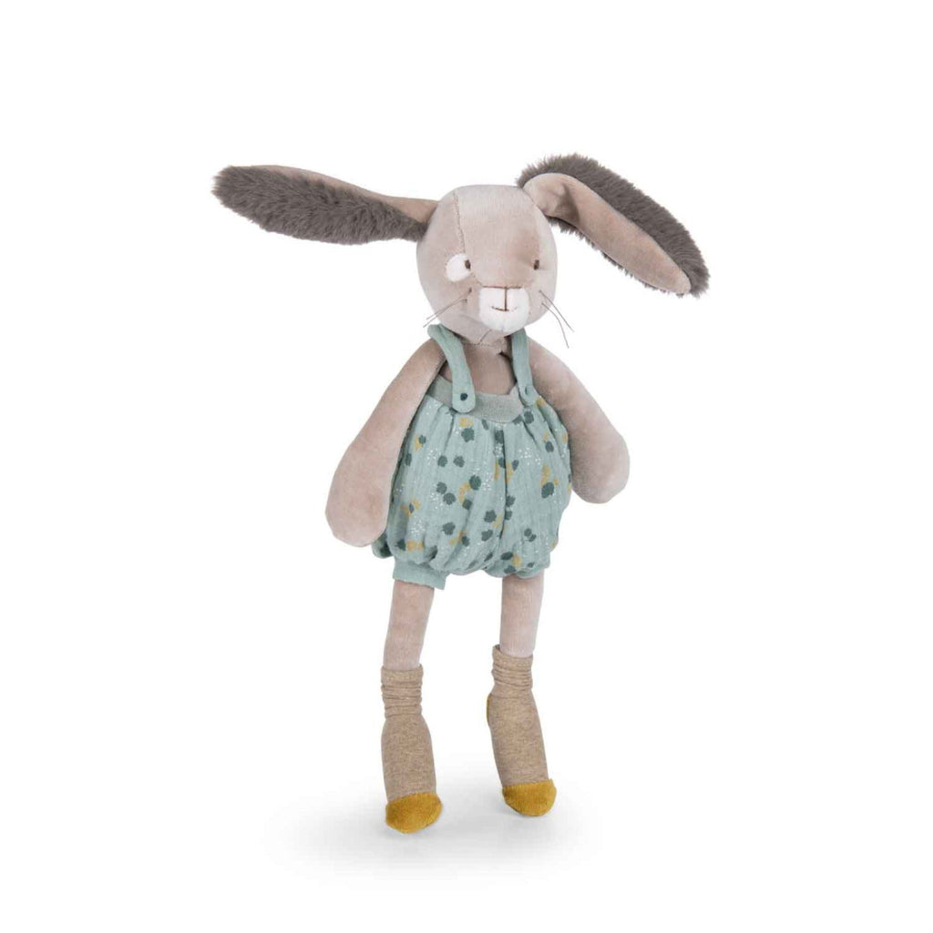 Stuffed bunny toy wearing a green romper with yellow polka dots on a white background