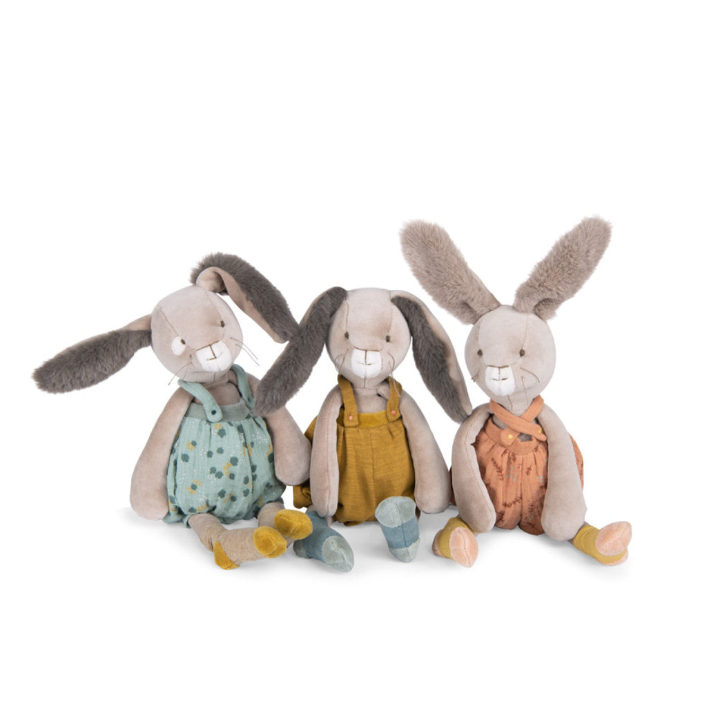 Three plush rabbit toys in colorful outfits on a white background