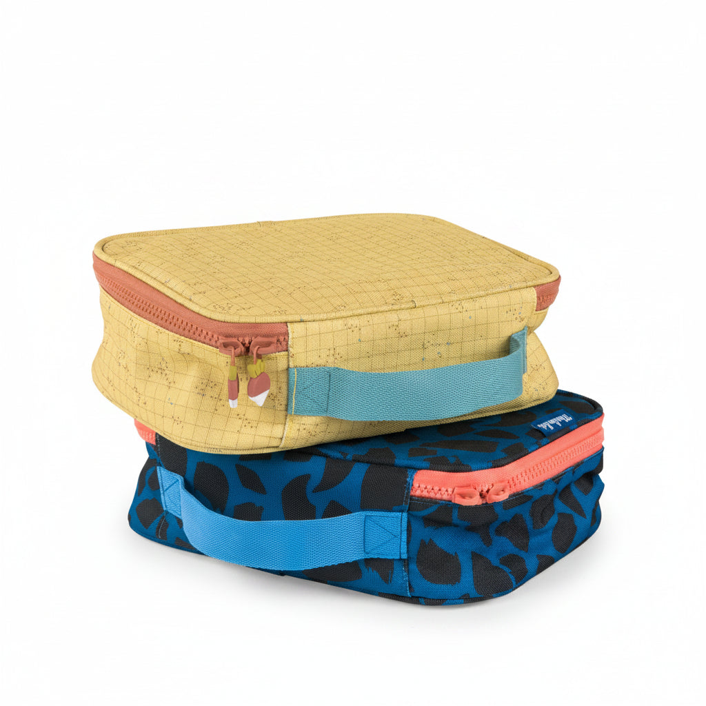 Stack of colourful tlunch bags with floral, cartoon, and abstract patterns on a white background
