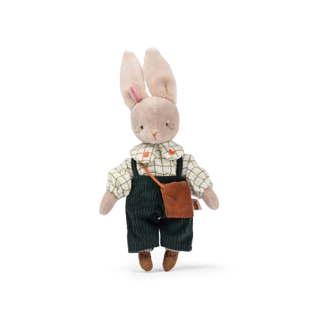 Stuffed toy rabbit wearing overalls and a shirt on a white background