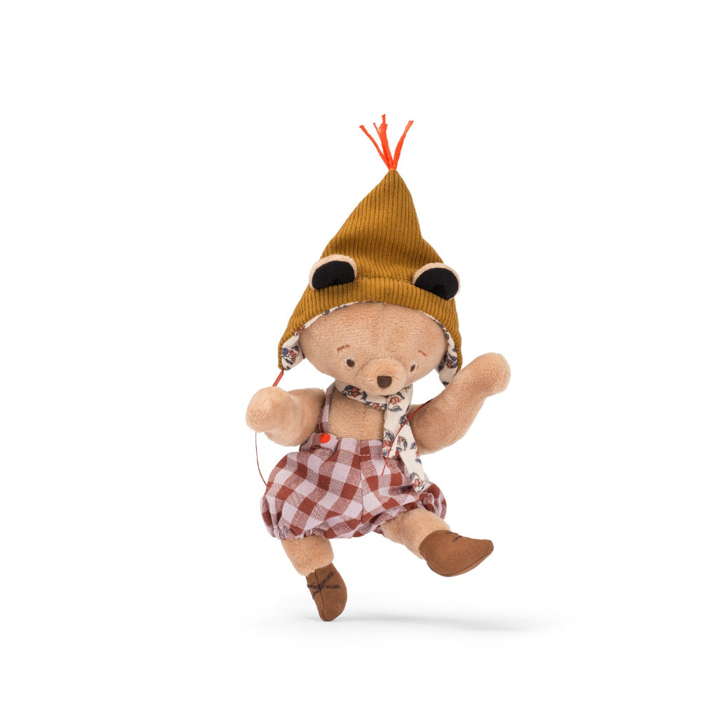 Stuffed toy bear wearing a hat and checkered overalls on a white background