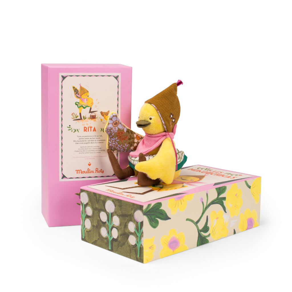 soft toy duck on box with a pink cover featuring text and illustrations.