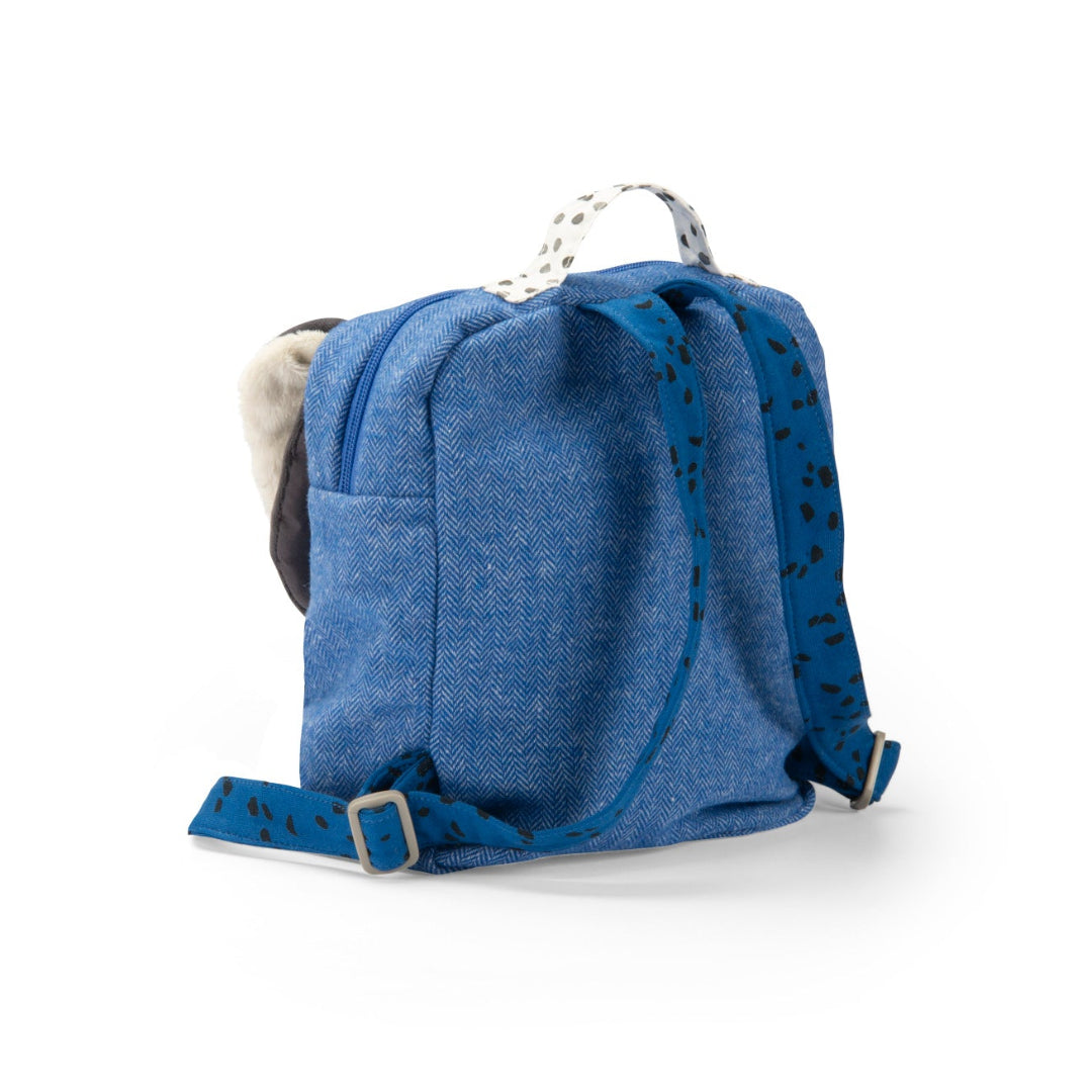 A small blue denim backpack with patterned straps, a white-and-black polka-dot top handle, and a grey plush ear on the side, shown against a plain white background.