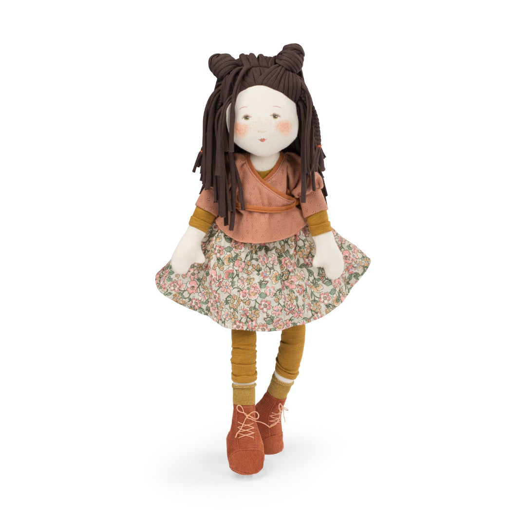 Stuffed doll with brown hair, floral dress, and brown shoes on a white background