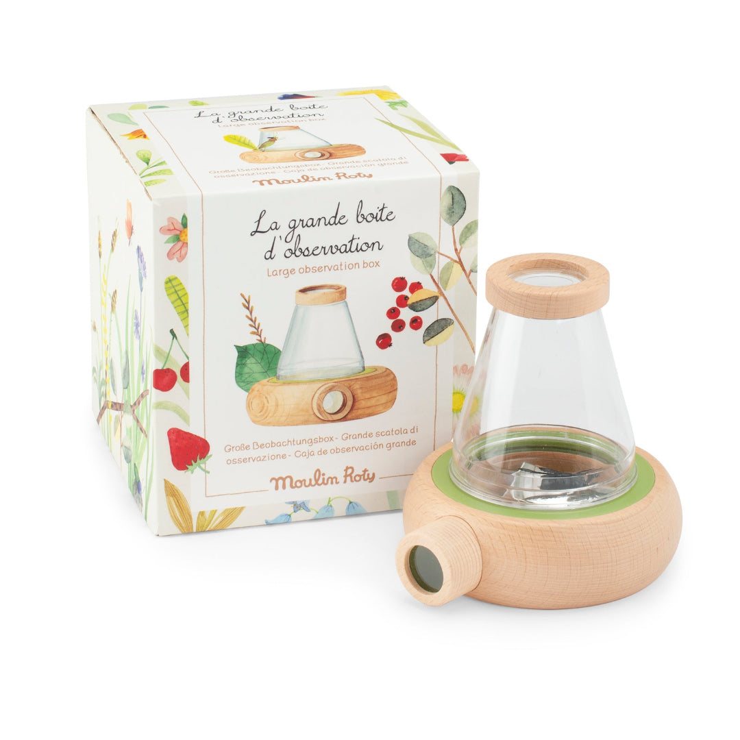 Observation bottle with wooden base and lid next to its packaging on a white background