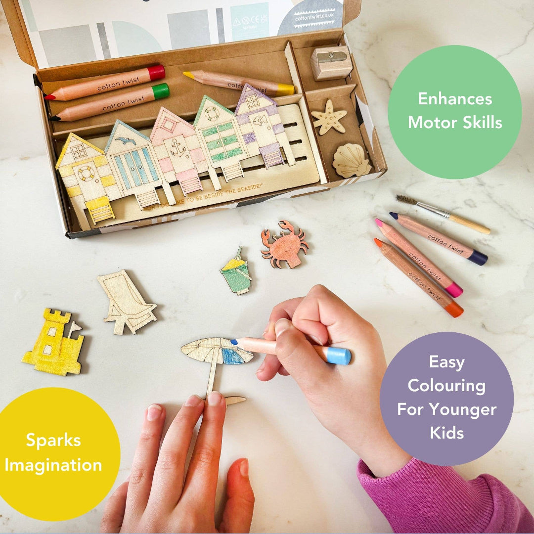 Children's craft set with houses and coloring tools on a table, promoting motor skills and imagination.