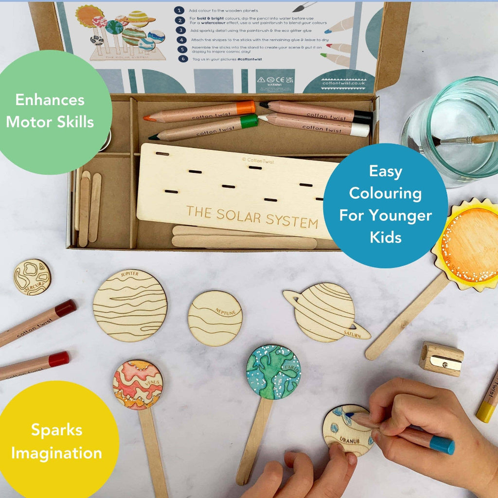 Wooden solar system model set with markers and coloring book on a table.