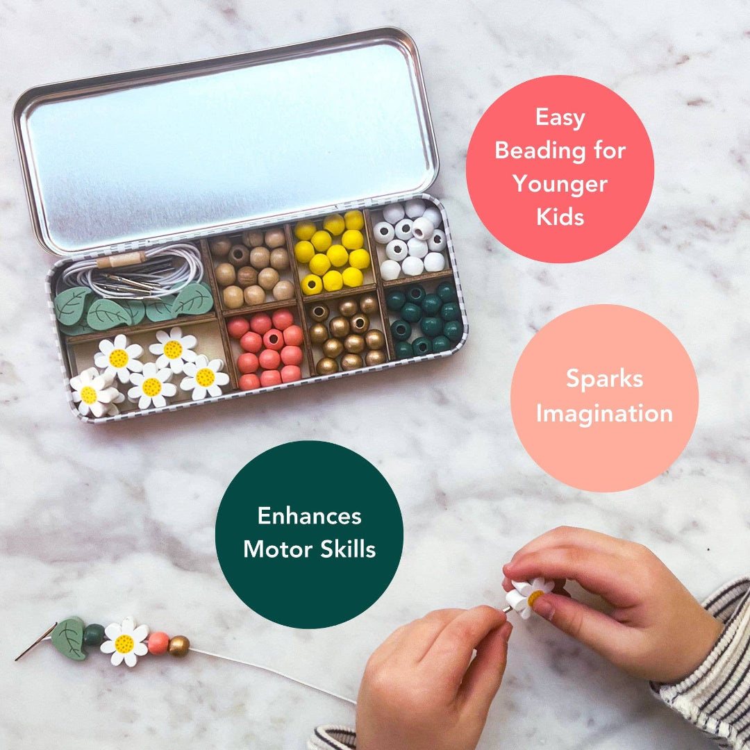 Bead set with colorful beads and a child's hands making a bead necklace on a marble surface.