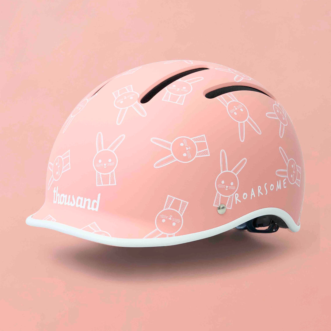 Pink helmet with white graphics on a pink background