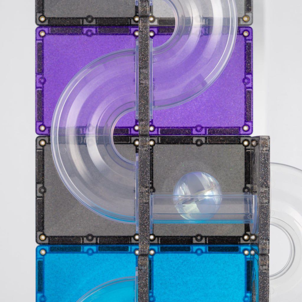 Clear CONNETIX ball run tubes and purple, blue and grey glitter magnetic tiles with a marble rolling through