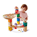 Child playing with a colorful wooden marble run toy set on a white background