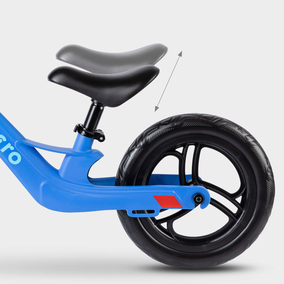 Close-up of the adjustable saddle on the blue Micro Balance Bike Lite, with an arrow showing height adjustment