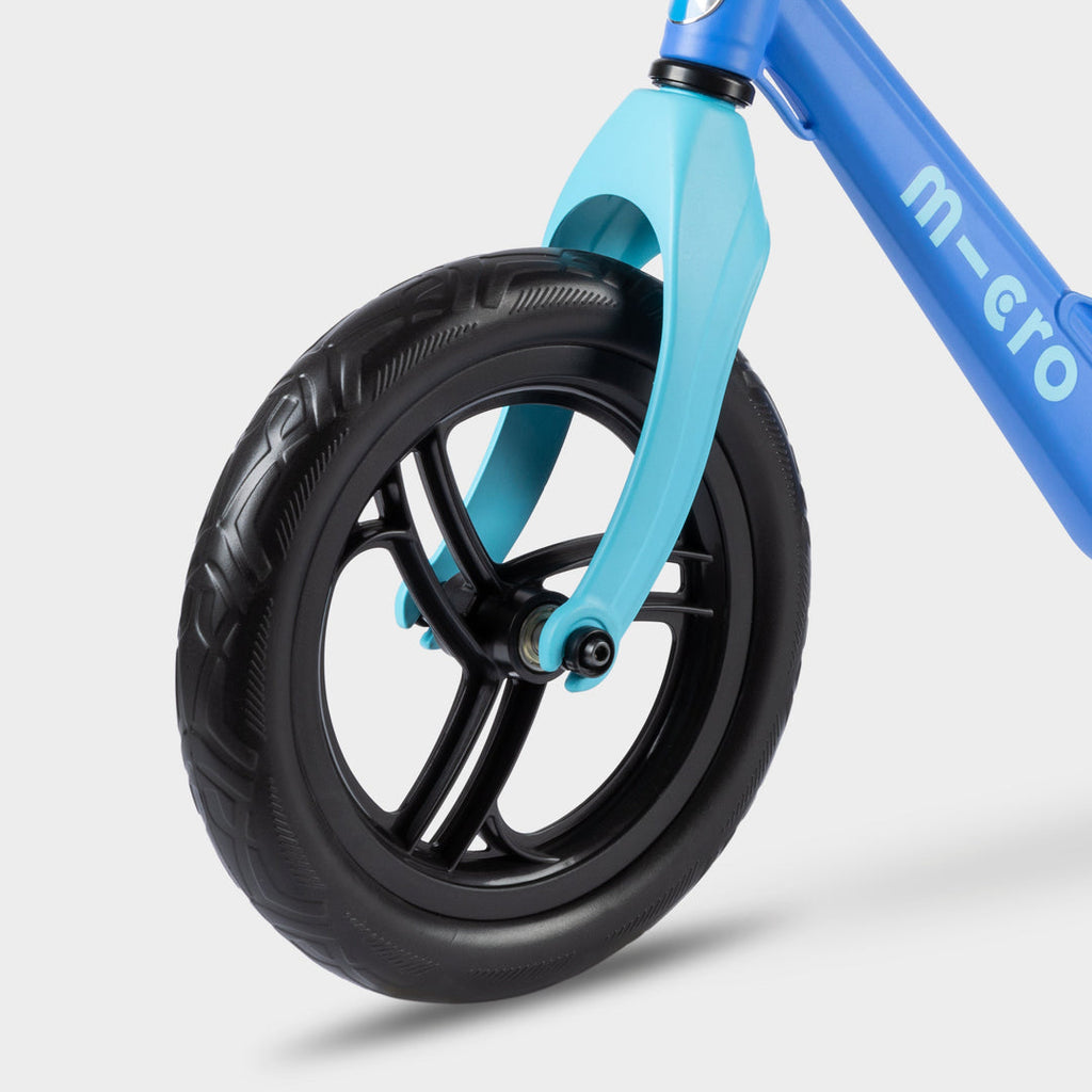 Close-up of the light blue front fork and black front wheel on the blue Micro Balance Bike Lite