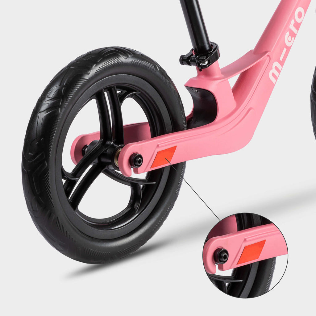 Close-up of the rear wheel on the pink Micro Balance Bike Lite with an inset of the red reflector