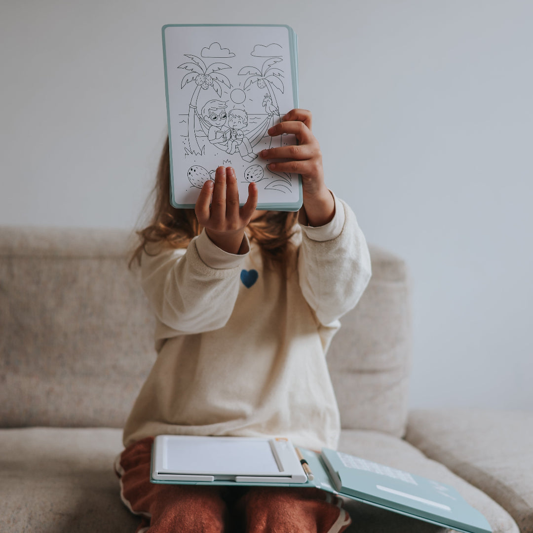Person sitting on a couch holding a kidydraw illustration above their face